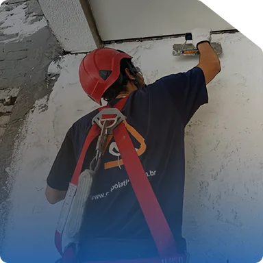 Equipe recuperando o revestimento da fachada de um edifício a partir de balancim