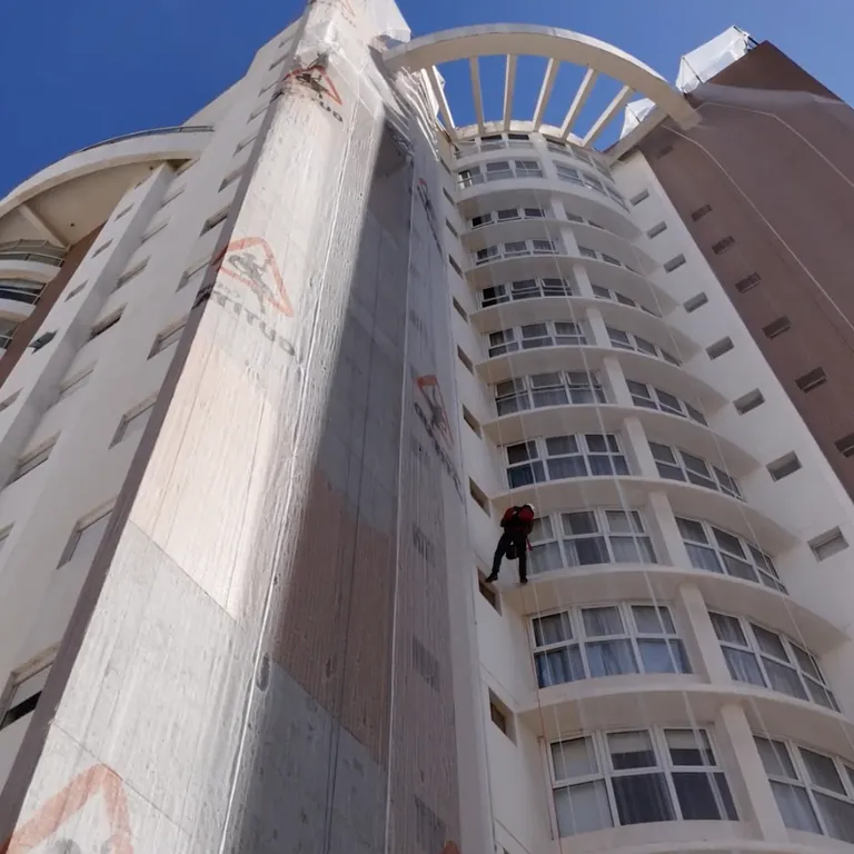 Pintura e restauração de fachada predial com acesso por corda em edifício alto